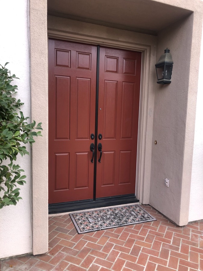 Double front doors finished in a deep red stain